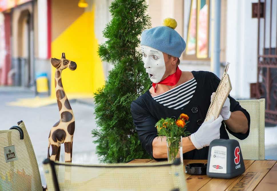 Giraffe bestellt nicht, aber hört zu. Französischer Pantomime-Künstler zeigt Menü einem Holz-Giraffen im Usedom
