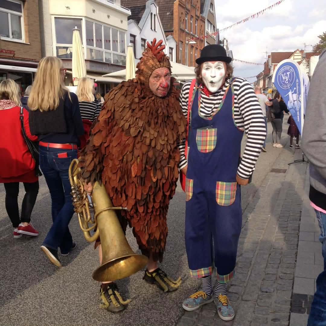 Pantomime-Künstler und Huhn beim humorvollen Walkact