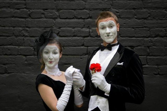 Atmospheric walkact on Usedom Walk-Act holding red flower in front of black wall